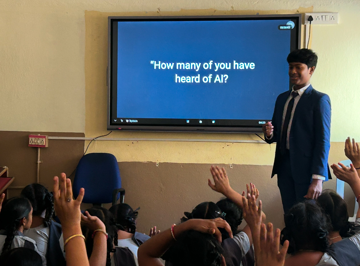 Shashank teaching a Lumin AI class, students with their hands up under a screen reading how many of you have heard of AI