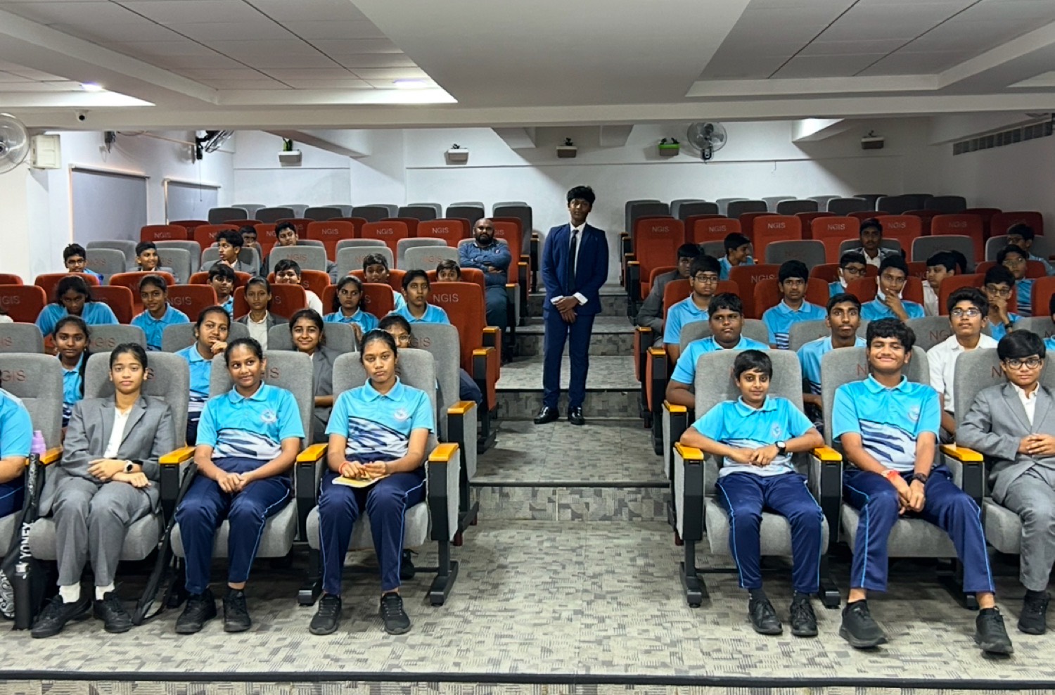 Group photo of a class in blue uniforms with Shashank standing in the aisle