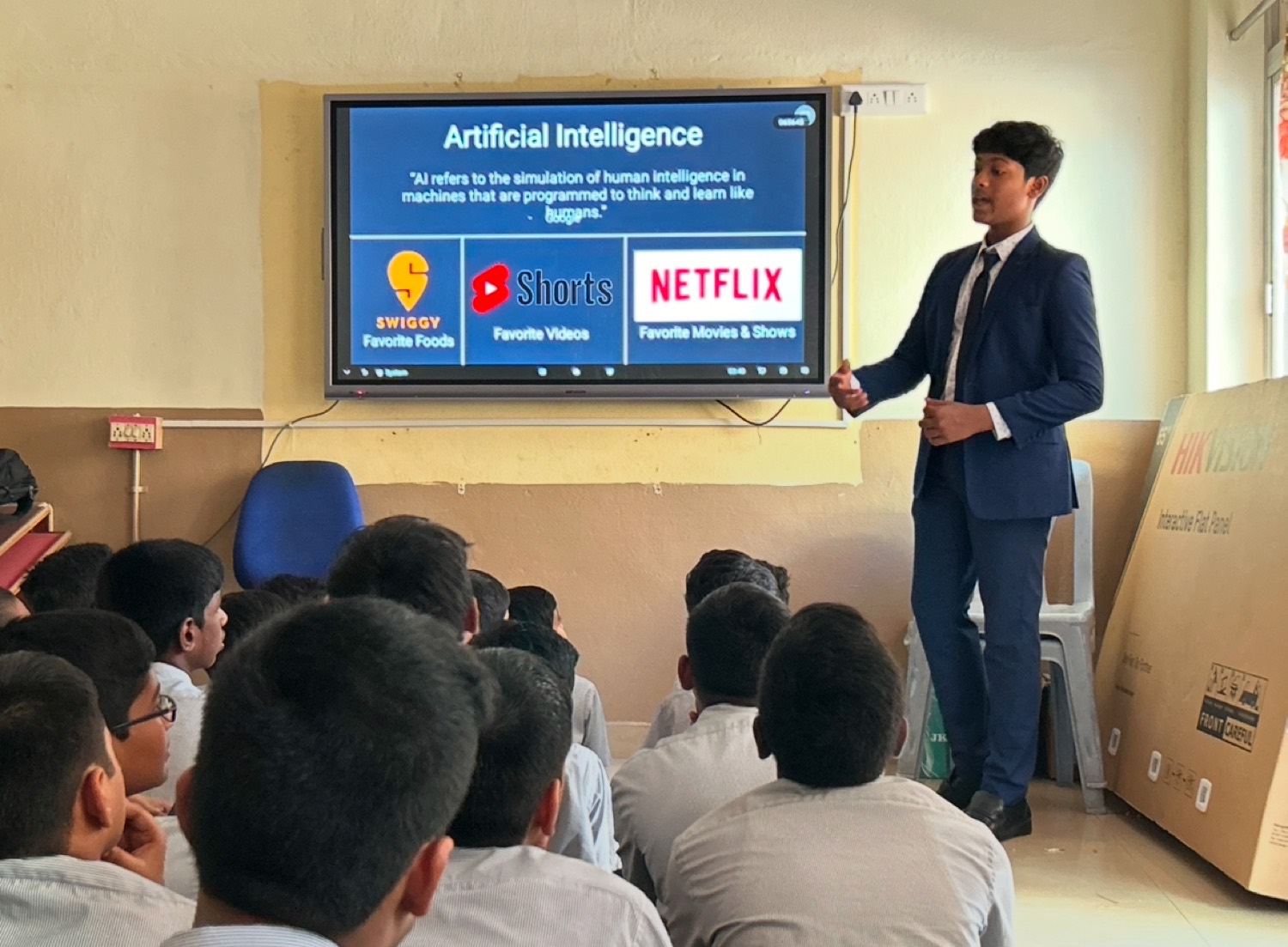 Shashank Madala mid lecture at a Lumin AI session, beside a slide explaining AI through Swiggy, YouTube Shorts and Netflix