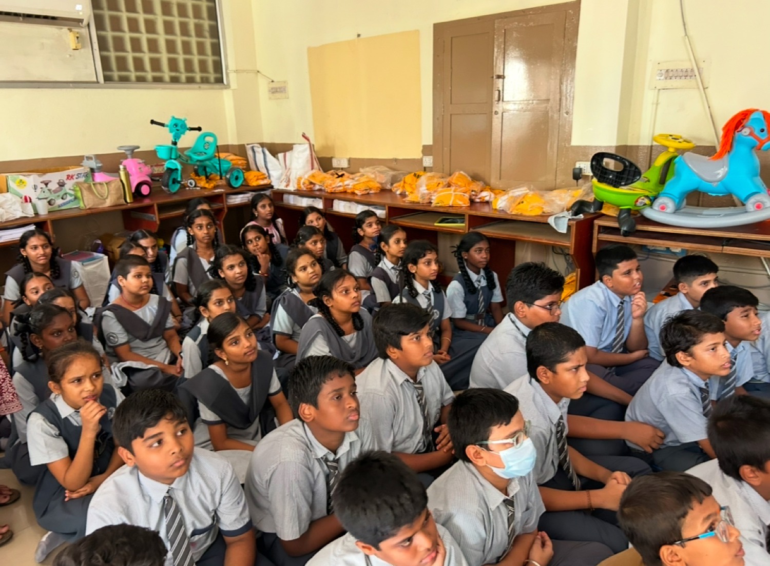 Students seated near the front of the room, listening during a session
